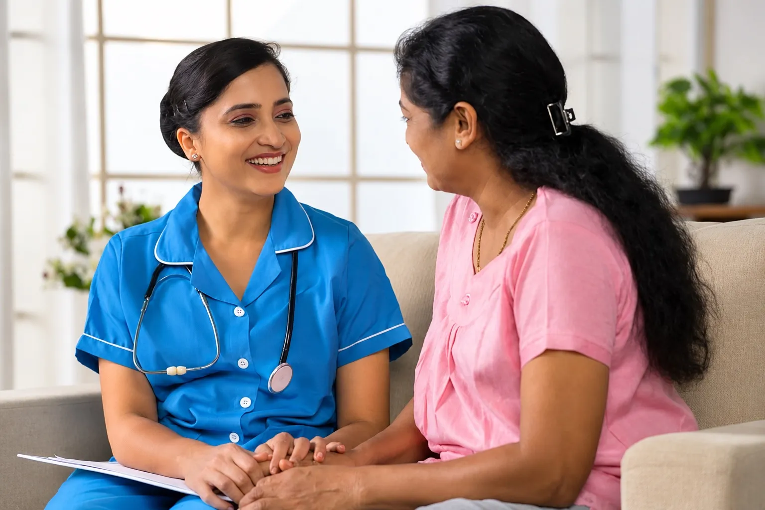 A healthcare professional speaking with a woman seated beside her.